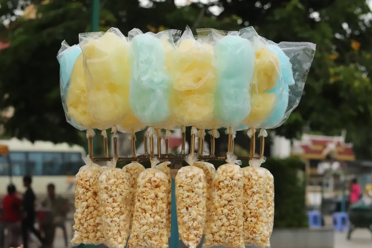 Vibrant display of cotton candy and popcorn at an outdoor market in Krong Pailin, Cambodia.