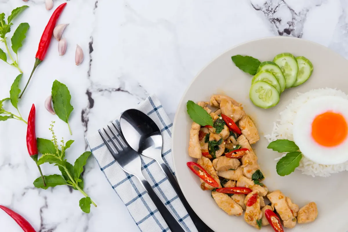 Delicious Thai basil chicken dish with steamed rice and fried egg.